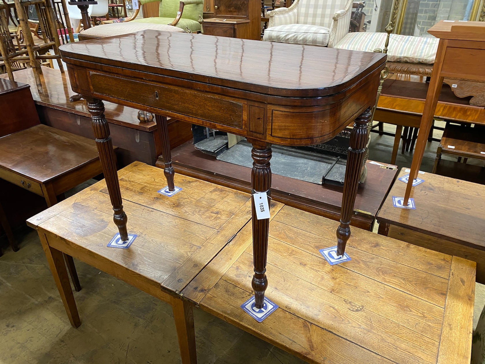A George IV Gillows style ebony strung mahogany folding tea table on fluted legs width 99cm, depth 48cm, height 76cm.